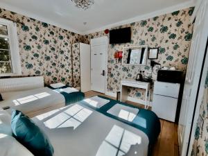 a small bedroom with two beds and a desk at The Bridge House in Hounslow