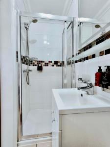 a white bathroom with a shower and a sink at The Bridge House in Hounslow +57 photos