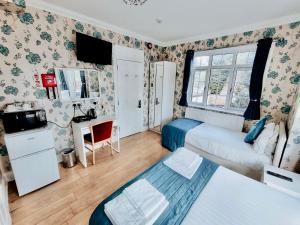 a small room with a bed and a window at The Bridge House in Hounslow