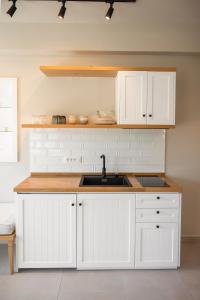 a kitchen with white cabinets and a sink at Elia Suites in Falasarna