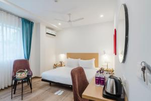 a hotel room with a bed and a table and chairs at RCC Hotels Elite Begumpet in Hyderabad +39 photos