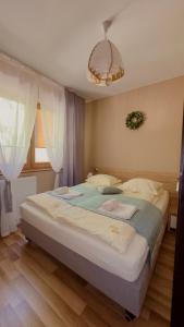 a large bed in a bedroom with a window at Rosa Apartamenty in Dąbki