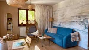 a living room with a blue couch and a table at Rosa Apartamenty in Dąbki