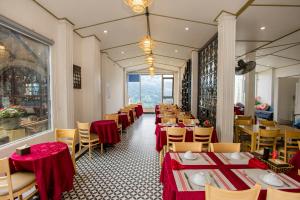 a dining room with tables and chairs with red table cloth at Terravia Hotel Sapa Moutain View in Sapa