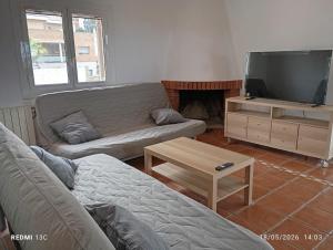 a living room with a couch and a tv at Private pool and garden in Cunit