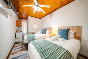 a bedroom with two beds and a ceiling fan at 3 Italeni in Secunda