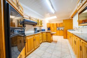 a large kitchen with wooden cabinets and appliances at 3 Italeni in Secunda
