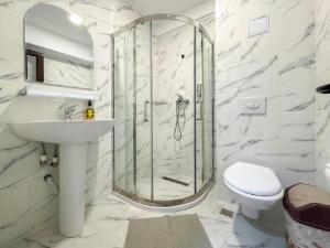 a bathroom with a shower and a sink and a toilet at Pensiunea Riviera in Costinesti