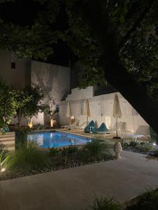 a swimming pool at night with umbrellas at Palazzo Rodio in Ostuni