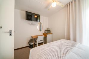 a bedroom with a bed and a desk with a mirror at 3 Italeni in Secunda