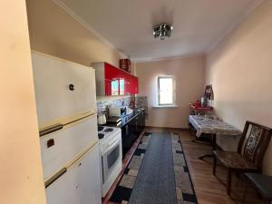 a kitchen with white appliances and red cabinets at Гостевой дом Достук in Bosteri