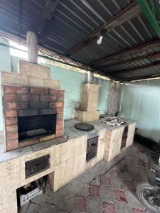 a kitchen with a brick oven in a room at Гостевой дом Достук in Bosteri