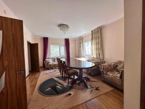 a living room with a table and a couch at Гостевой дом Достук in Bosteri