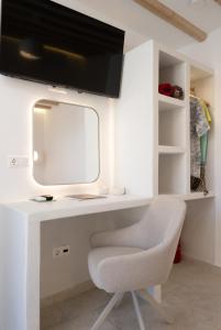 a white desk with a monitor and a chair at Ethereal House - Seafront by Cheronissos Beach in Cherronisos