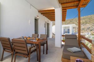 a dining room with a wooden table and chairs at Ethereal House - Seafront by Cheronissos Beach in Cherronisos