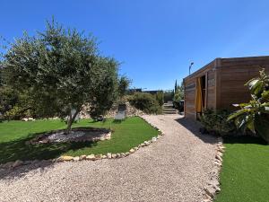 a garden with a tree and a house at Le cosy d'Aramon in Aramon