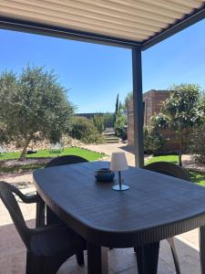 a black table with chairs and a lamp on a patio at Le cosy d'Aramon in Aramon
