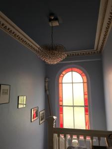 a chandelier hanging from a ceiling with a window at Dorstan House in Edinburgh