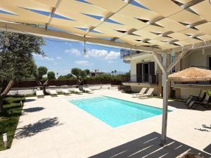 a patio with a pool and an umbrella at Kiro Apartment Experience Pompei in Angri