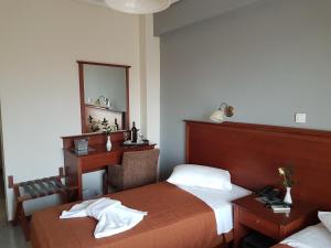 a bedroom with a bed and a desk and a mirror at Apollo Hotel in Athens