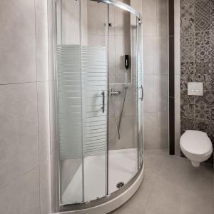 a shower stall in a bathroom with a toilet at Tridente Mare Apart Hotel in Pefkochori +98 photos