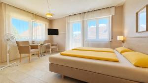 ein Schlafzimmer mit einem Bett, einem Tisch und Stühlen in der Unterkunft Hotel-Heilsberg in Gottmadingen