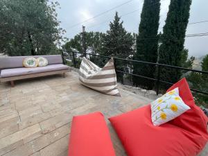 a patio with couches and pillows on a balcony at Maison de Bentaël in Jbeil