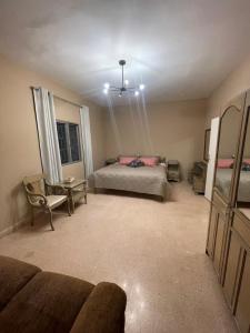 a bedroom with a bed and a couch and a chair at Maison de Bentaël in Jbeil