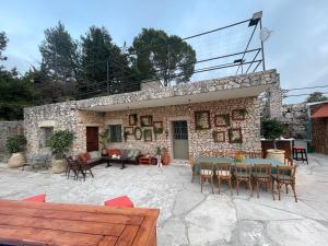 a stone building with a patio with a table and chairs at Maison de Bentaël in Jbeil