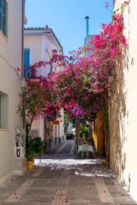 a street with pink flowers in an alley at DownTown Hotel in Nafplio