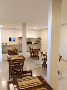 a dining room with wooden tables and chairs at Pousada Mares Maragogi in Maragogi