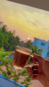 a person is holding a glass of wine at Beach Residency in Kāsarkod