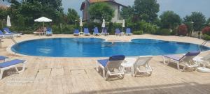 a swimming pool with chairs and a person in it at Apartman RS 27 Апартамент на плажа с вълшебна гледка към морето, напълно оборудвана кухня и безплатен паркинг, със самостоятелен басейн, балкон и асансьор Самостоятелен душ и тоалетна ТОП местоположение in Lozenets