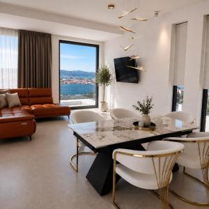 a living room with a table and chairs and a couch at White Hills Villa in Zadar