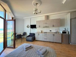 eine Küche und ein Wohnzimmer mit einem Bett in der Unterkunft SofiCoast in Gonio