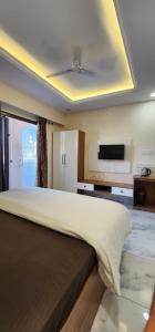 a bedroom with a large bed with a flat screen tv at Pratap Royal Stay in Ujjain