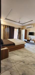 a bedroom with a large bed and a flat screen tv at Pratap Royal Stay in Ujjain