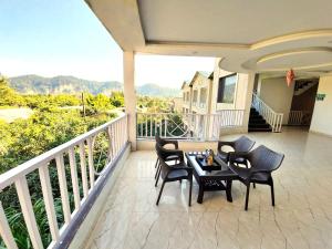 a balcony with chairs and a table on a balcony at DL Hotels & Resorts Corbett in Dhikuli