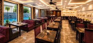 a restaurant with wooden tables and purple chairs at DL Hotels & Resorts Corbett in Dhikuli