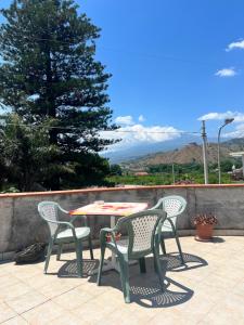 a table and chairs on a patio with a tree at Estía Holidays Apartments - Taormina in Taormina