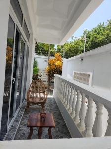 a porch with a chair and a table at AC one bedroom apartment , 5 min walk from bofa road, baobab resort ,Canna Lily in Kilifi