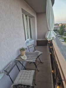 a balcony with two chairs and a table and an umbrella at Apartament Jaroty dla 4 osób in Olsztyn