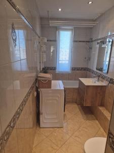 a bathroom with a tub and a toilet and a sink at Apartament Jaroty dla 4 osób in Olsztyn