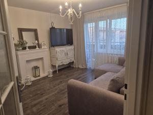 a living room with a couch and a flat screen tv at Apartament Jaroty dla 4 osób in Olsztyn