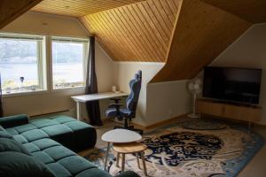 a living room with a couch and a tv at Villa Valentina by Arctic Prive - Northern Lights Villa with Sauna & Fjord View in Alta in Alta