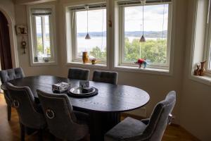 a dining room with a table and chairs and windows at Villa Valentina by Arctic Prive - Northern Lights Villa with Sauna & Fjord View in Alta in Alta