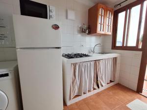 a white kitchen with a stove and a refrigerator at Estudio Mary Espectaculares Vistas al Mar in Los Llanillos