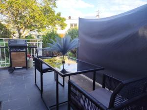 a patio with a glass table and two chairs at Appartement meublé Rixheim Alsace in Rixheim