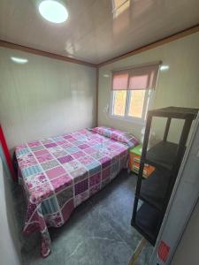 a small bedroom with a bed and a window at Mar y campo in Algarrobo-Costa