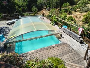 an empty swimming pool on a wooden deck at Chambre privative in Lecci